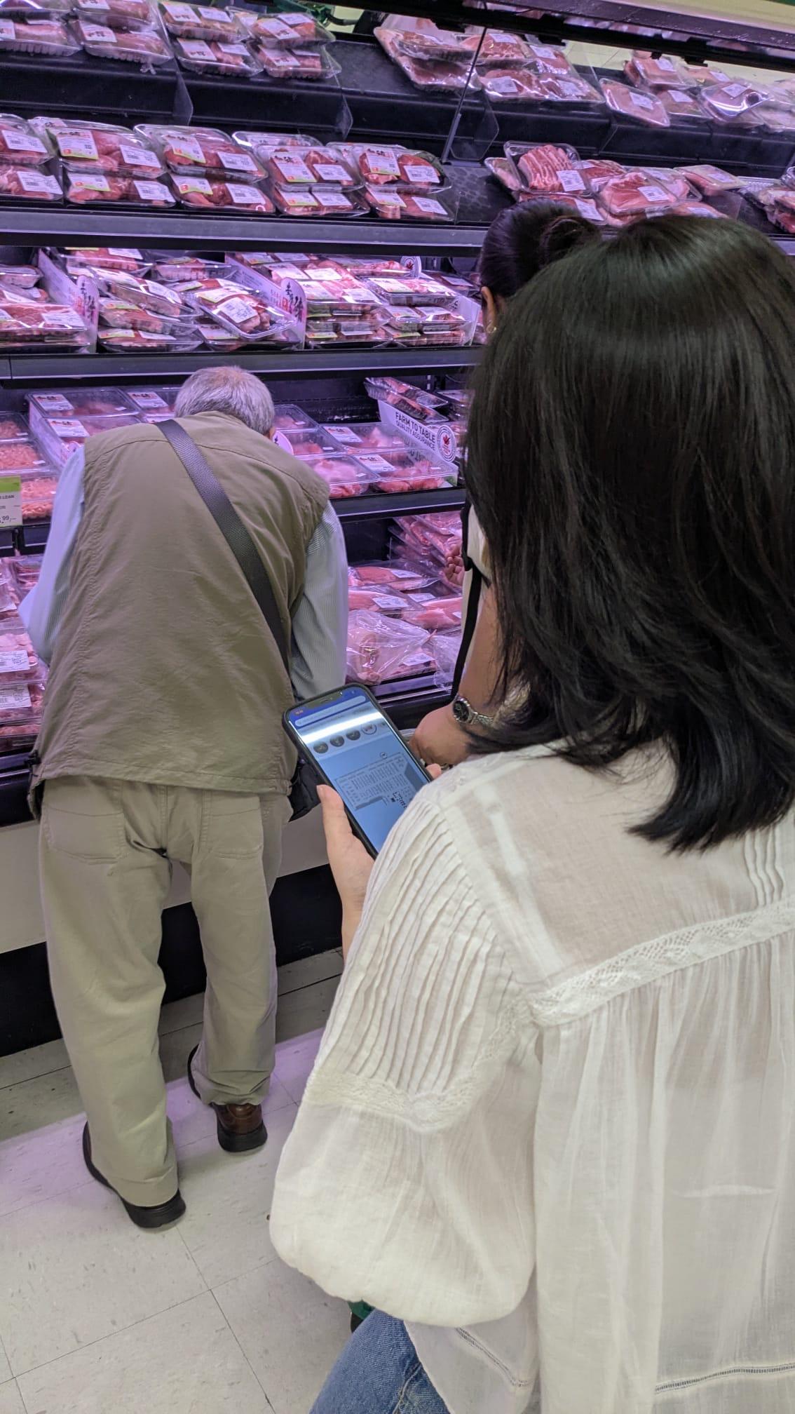 Shopper checking Grocery Nav in the meat aisle